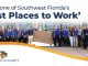 A large group of Naples Airport Authority employees pose outside by a Naples Aviation sign, under a banner naming them a 2023 Best Places to Work in Southwest Florida.
